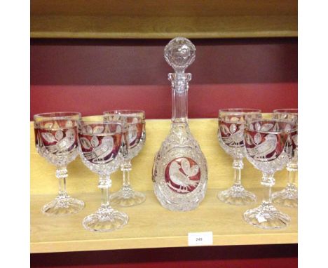 A Bohemian cut glass decanter and 6 glasses with red panels and bird decoration.