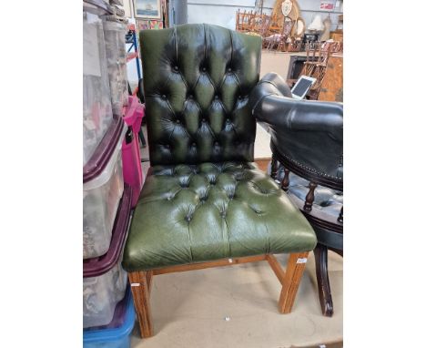 A green leather Chesterfield button back chair. 