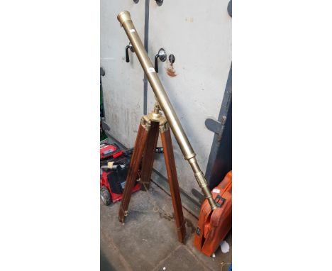 A brass telescope on a wooden tripod 