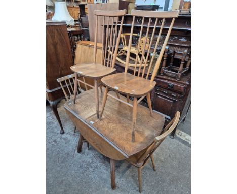 An Ercol pine drop leaf table together with four Ercol light elm dining chairs (model 608).