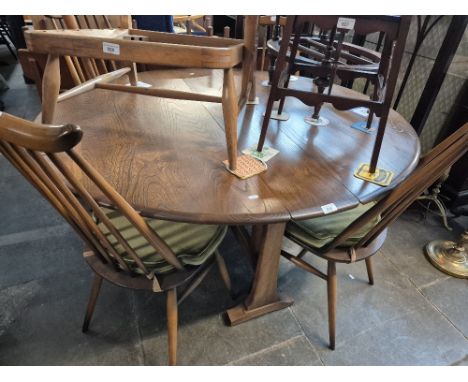 An Ercol elm drop leaf table and four Ercol 'Goldsmith' chairs. 