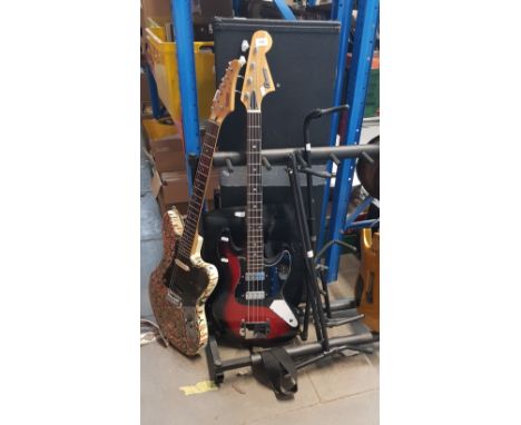 A Columbus bass guitar, a Hohner JT160 electric guitar with hard case, two guitar stands and a Fender electric guitar bag.