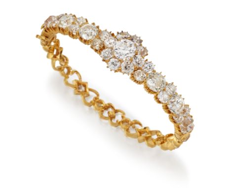 A DIAMOND BANGLE, a central cluster of round-cut diamonds between rows of alternating pairs and single diamonds, to a fancy s