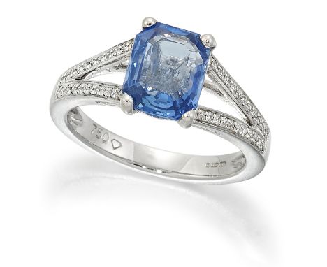 AN 18 CARAT WHITE GOLD SAPPHIRE AND DIAMOND RING, an octagonal-cut sapphire in a claw setting, to diamond set forked shoulder