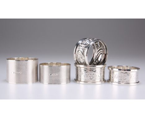 FOUR SILVER NAPKIN RINGS, comprising two with engine-turned ground and two with scroll engraving; together with AN UNMARKED N