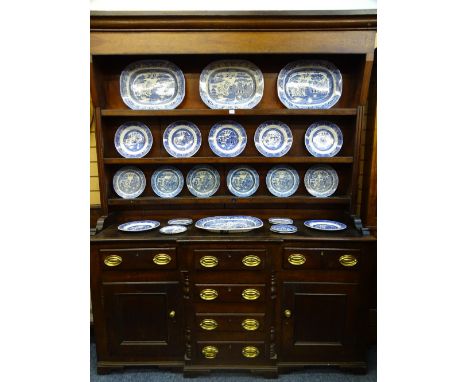 CIRCA 1840 NORTH WALES BREAKFRONT DRESSER in oak and pine, the three shelf rack with wide backboards over a base top with edg