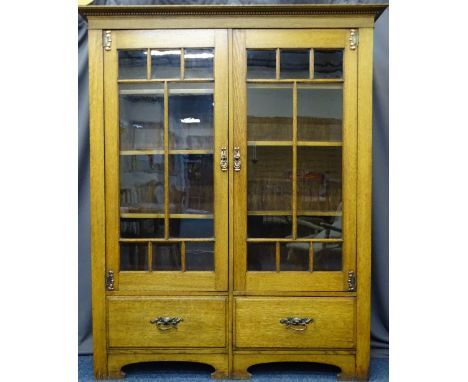OAK ARTS &amp; CRAFTS BOOKCASE having twin eight panel upper glazed doors with interior adjustable shelving above a pair of l