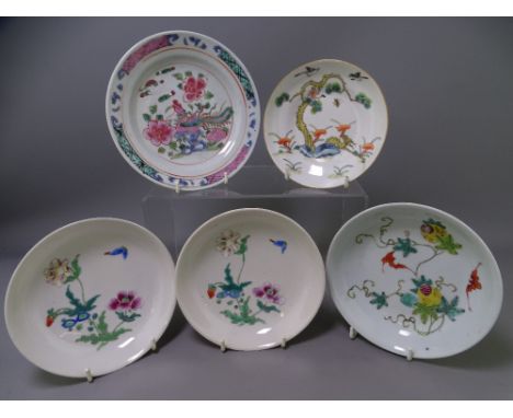 FIVE ORIENTAL PORCELAIN DISHES/SAUCERS having various enamel decoration including a bat and fruit decorated example, 15.75cms