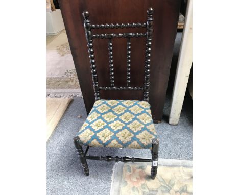 An Edwardian stained beech bobbin turned child's chair, with tapestry seat, 70 cm high.