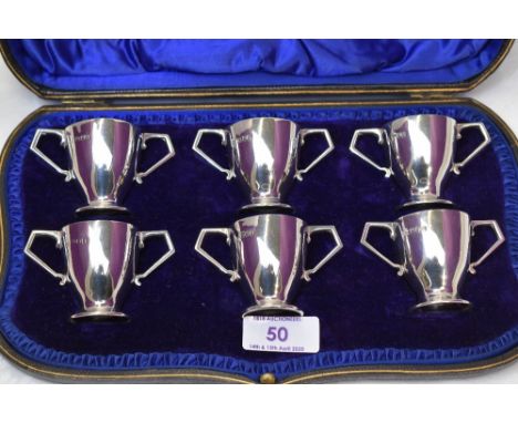 A cased set of six Edwardian silver tot glasses of two handled trophy form, London 1904, Wakeley &amp; Wheeler
&nbsp;
Weight 