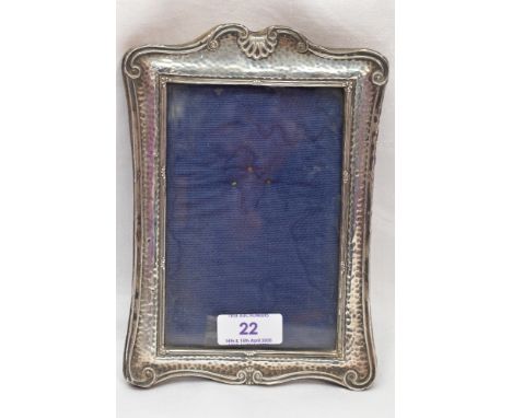 An Edwardian silver photograph frame having plannished decoration and moulded scallop and scroll rim, missing easel stand, Bi