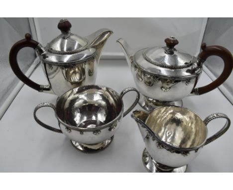 A four piece silver tea set of Artisan style having soft wood handles and knops, silver wire appliqué decoration and gadroone