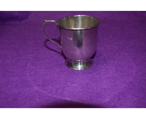 A small HM silver christening tankard of plain form having loop handle with thumb plate and pedestal foot, Birmingham 1931, E