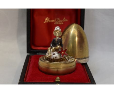 A cased Stuart Devlin 1975 silver gilt limited edition surprise Easter egg having a polished exterior opening to to reveal a 