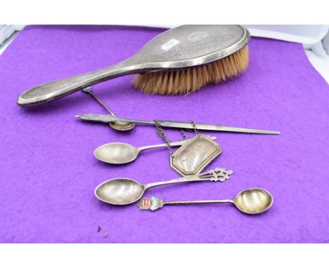 A small selection of HM silver including souvenir spoons, dressing table hair brush, letter opener and whisky decanter label