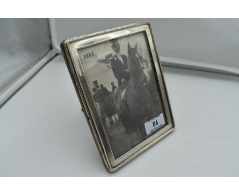 A silver photograph frame of plain rectangular form having wooden easel stand, London 1918, A &amp; J Zimmerman
Condition Rep