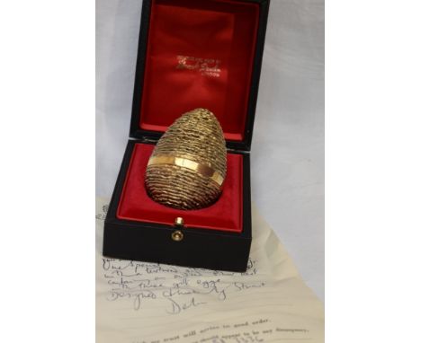 A cased Stuart Devlin 1971 silver gilt surprise Easter egg having a textured exterior opening to reveal an oxidised bird nest