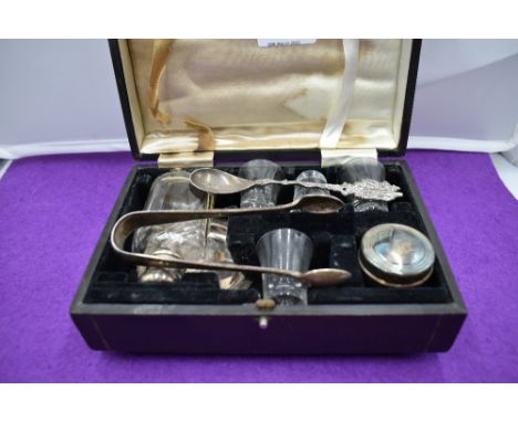 A silver plated travel communion set containing lidded bottle, jar, four glasses and plate, and a pair of HM silver sugar nip