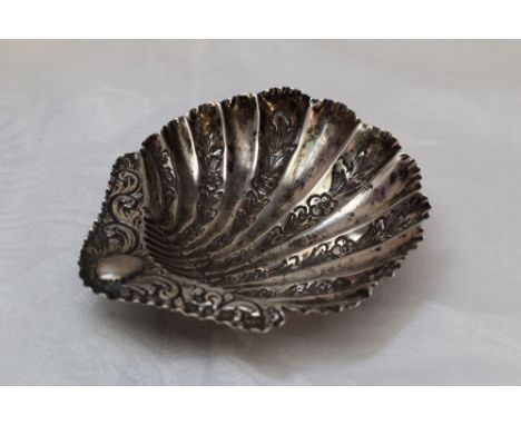 A small Victorian silver butter dish of scallop shell form having floral engraved decoration and trefoil bun feet, Birmingham