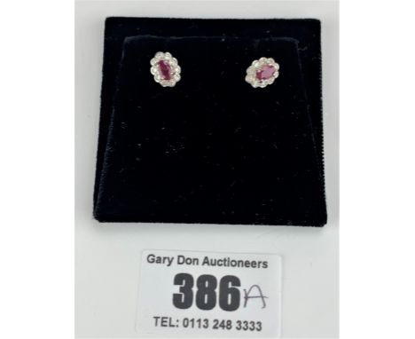 Pair of 9k gold oval shaped ruby and diamond cluster earrings, w: 1.2 gms