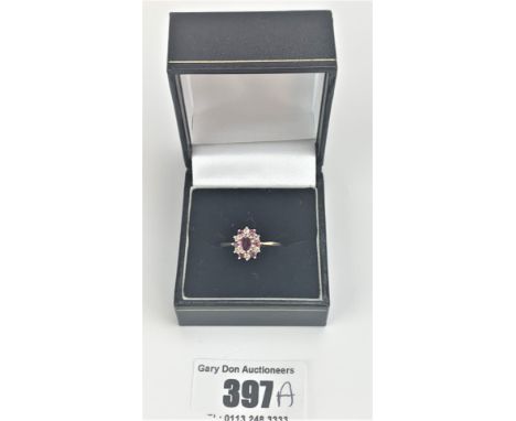 9k gold oval shaped ruby and diamond cluster ring, size P, w: 2.2 gms