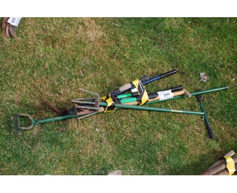 A bundle of tools including shears, long handled cultivator, etc.,