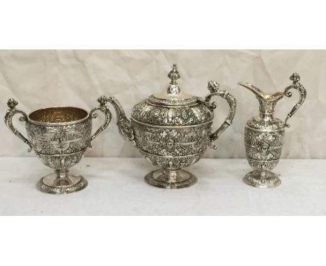 A Victorian silver three piece tea service by Steven Smith, London 1871 "Cellini" pattern engraved with a crest and motto for