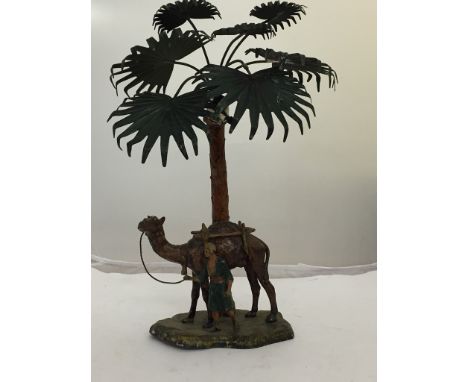 An Austrian cold painted spelter lamp of an Arab with a camel under a palm tree, marked to the base "Austria"