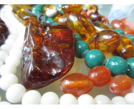 Quantity of loose amber coloured beads, a quantity of bead necklaces and a bangle