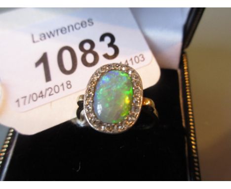 Yellow metal ring set central opal surrounded by diamonds