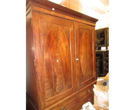 George III mahogany and line inlaid linen press, the moulded cornice above a pair of oval panel doors enclosing hanging space