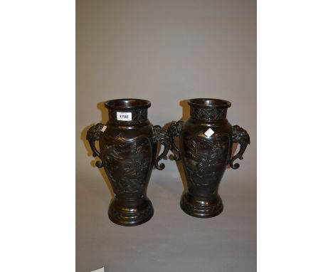 Pair of late 19th Century Japanese dark patinated bronze two handled vases decorated in relief with flowers and birds