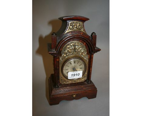 Small Continental oak cased mantel clock, having brass mounted decoration and circular silvered dial with Roman numerals