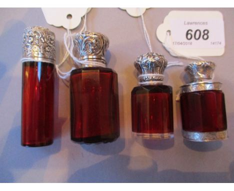 Group of four various ruby glass perfume bottles with white metal mounts, ranging in height from 4.5cms to 7cms