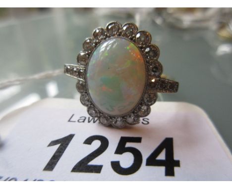 18ct Yellow gold opal and diamond ring, the oval opal approximately 13m x 10mm surrounded by a band of small diamonds and dia