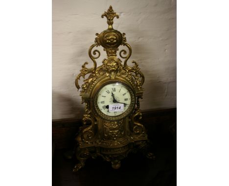 Late 19th Century gilt brass mantel clock having ornate cast case with mask head decoration, the circular dial with Roman num