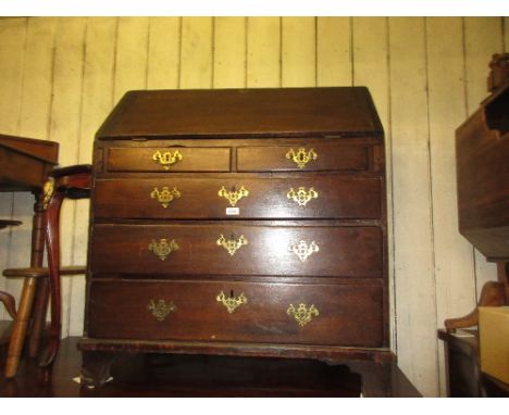 Early 19th Century oak bureau, the fall front enclosing a fitted interior over two short and three long graduated drawers wit