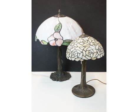 Two Tiffany style stained glass lampshades on table lamp bases, smaller rose pattern example with Art Nouveau tree trunk styl
