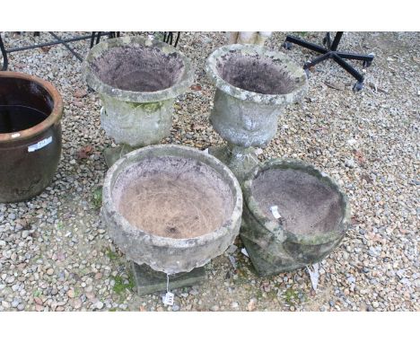 Four reconstituted stone garden planters to include a pair of urns with moulded details and smaller basin style pots, tallest