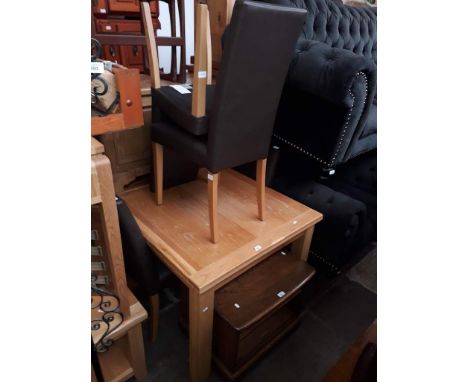 A modern light oak dining table and four chairs. 