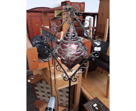A wrought metal and glass standard lamp. 