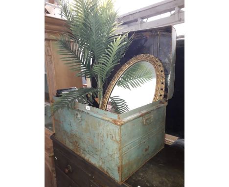 A tin and contents including a gilt framed mirror, a timing clock and a faux plant. 
