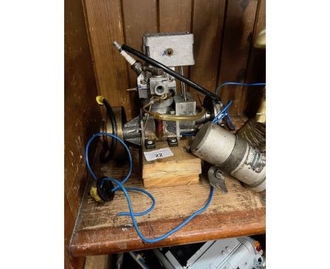 A small model engine complete with spark plug, ignition coil mounted on a wooden base 