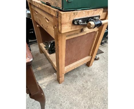 A woodworking bench with vice and with drawers containing various tools to include planes, chisels, saws, etc.