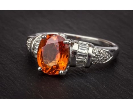 A 9ct gold, orange stone and diamond ring the oval cut centre stone, possibly a fire opal, over baguette and pavé set diamond