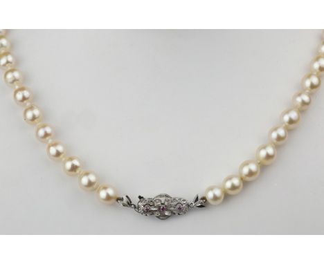 A single strand cultured pearl necklace with 18ct white gold and ruby clasp the 37in. (94cm.) string of approx. 8mm. pearls w