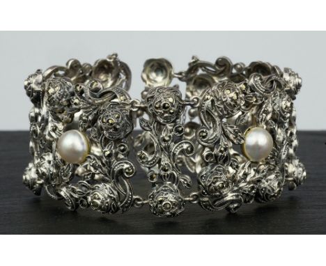 An antique Continental silver, marcasite and pearl bracelet 1920s-30s, the bracelet of elaborate pierced foliate design, the 