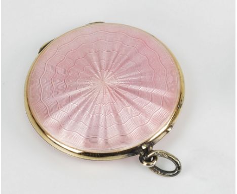 A silver locket of counter form with pink guilloche enamel circle decoration to both sides, 1¼in. (3.2cm.) diameter.