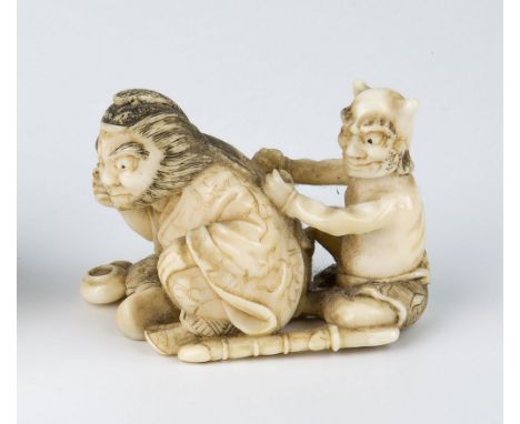 A late 19th century Japanese carved ivory netsuke depicting a seated Samurai with demonic figure to his rear, 2in. (5.1cm.) l