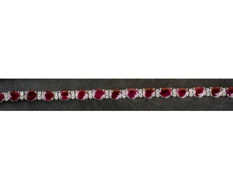 An 18ct white gold, Burmese ruby and diamond bracelet set with nineteen oval cut rubies, totalling 27.2 carats, alternating w